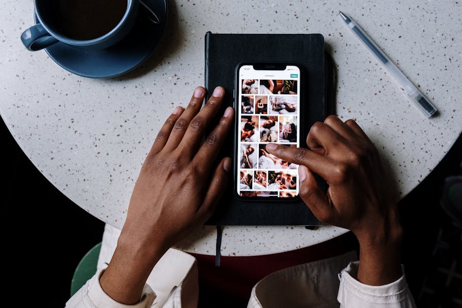 Close-up of hands using smartphone on a cafe table with coffee, highlighting social media browsing.